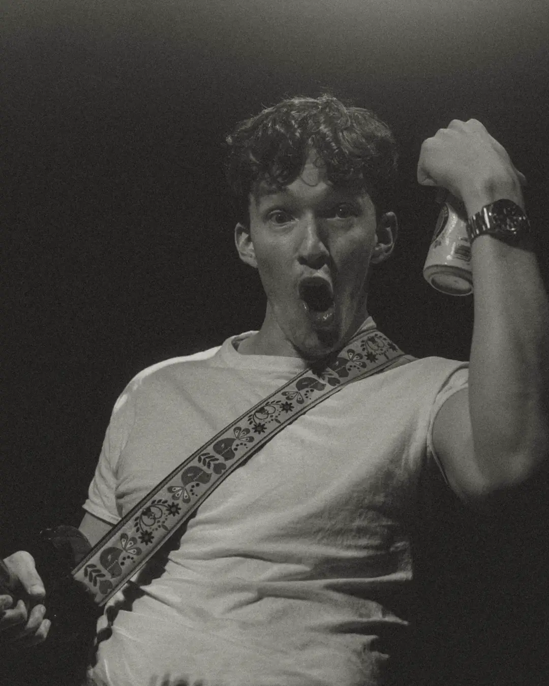 Mid-song with a can raised, shot in black and white.
