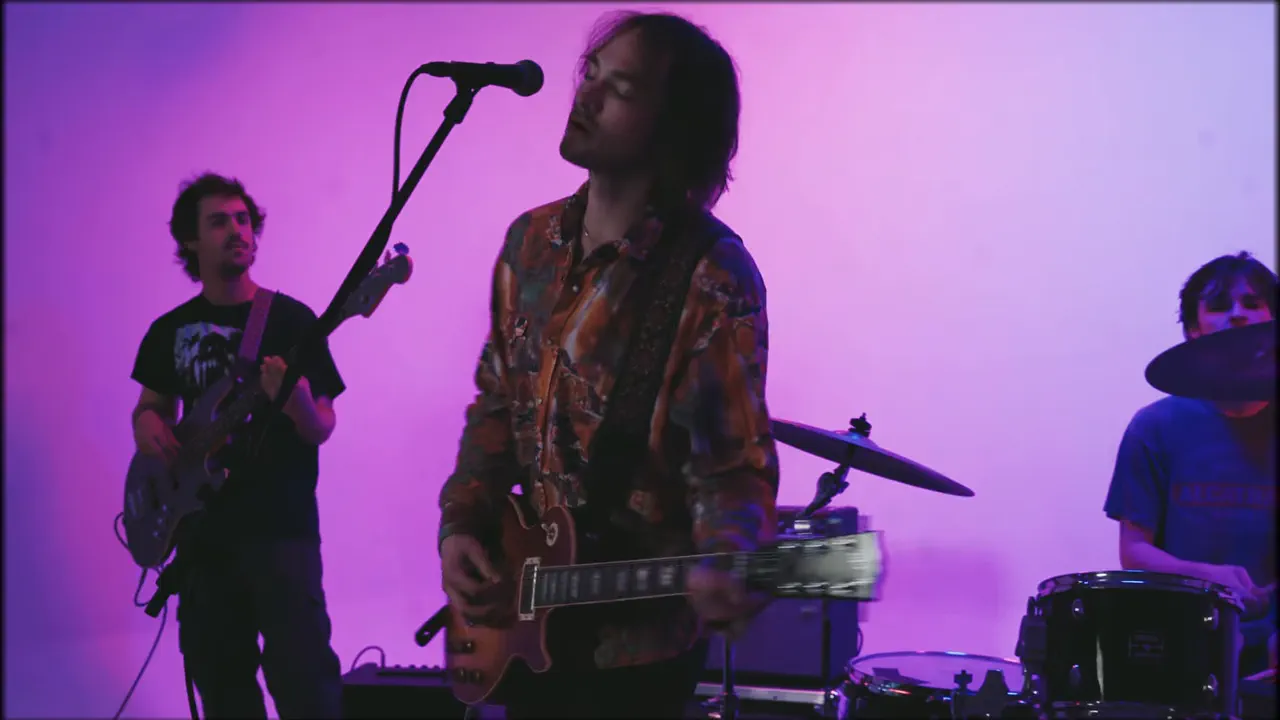 ASHES playing on a magenta-lit stage in the Where You Going? video.